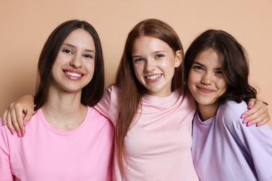 Photo of Portrait of happy friends on beige background