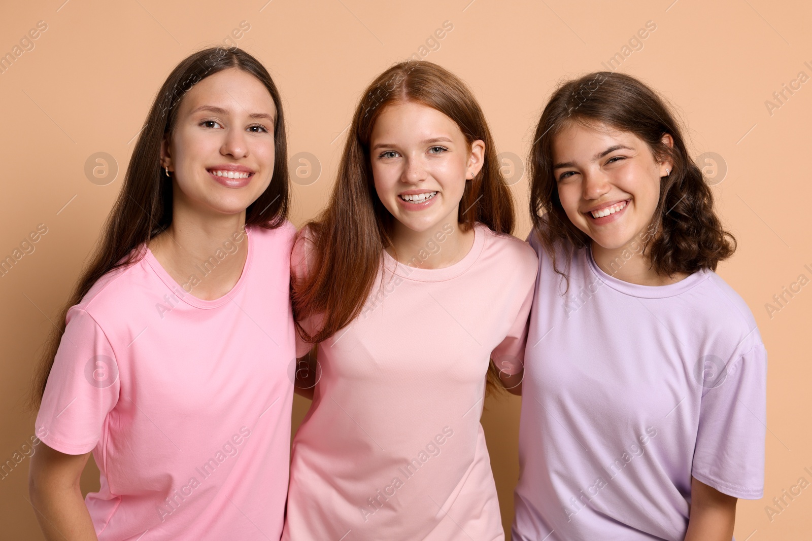 Portrait of happy friends on beige background Photo of Portrait of happy friends on beige background