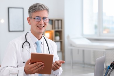 Photo of Telemedicine. Doctor having video call with patient via tablet indoors