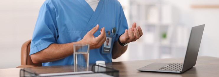 Photo of Telemedicine. Doctor having video call with patient via laptop indoors, closeup