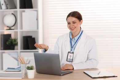 Photo of Telemedicine. Doctor having video call with patient via laptop indoors