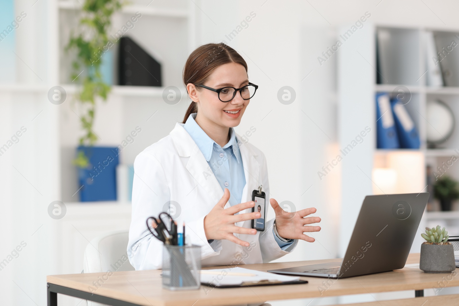 Telemedicine. Doctor having video call with patient via laptop indoors Photo of Telemedicine. Doctor having video call with patient via laptop indoors