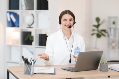 Photo of Telemedicine. Doctor having video call with patient via laptop indoors