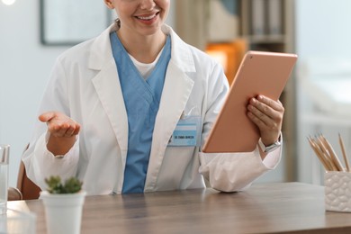 Photo of Telemedicine. Doctor having video call with patient via tablet indoors, closeup