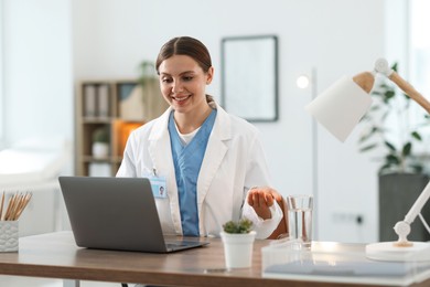 Photo of Telemedicine. Doctor having video call with patient via laptop indoors