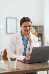 Photo of Telemedicine. Doctor having video call with patient via laptop indoors