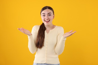 Photo of Beautiful woman laughing on yellow background. Positive emotion
