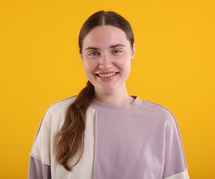 Photo of Beautiful woman laughing on yellow background. Positive emotion