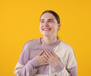 Photo of Beautiful woman laughing on yellow background. Positive emotion