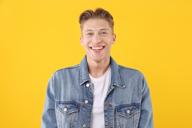 Photo of Handsome man laughing on yellow background. Positive emotion