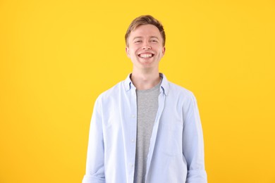 Photo of Handsome man laughing on yellow background. Positive emotion