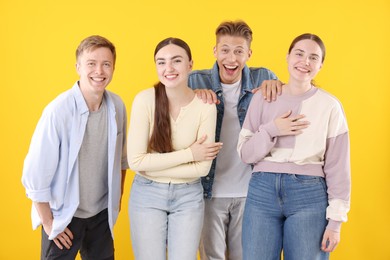 Photo of Friends laughing on yellow background. Positive emotion