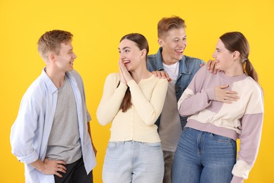 Photo of Friends laughing on yellow background. Positive emotion