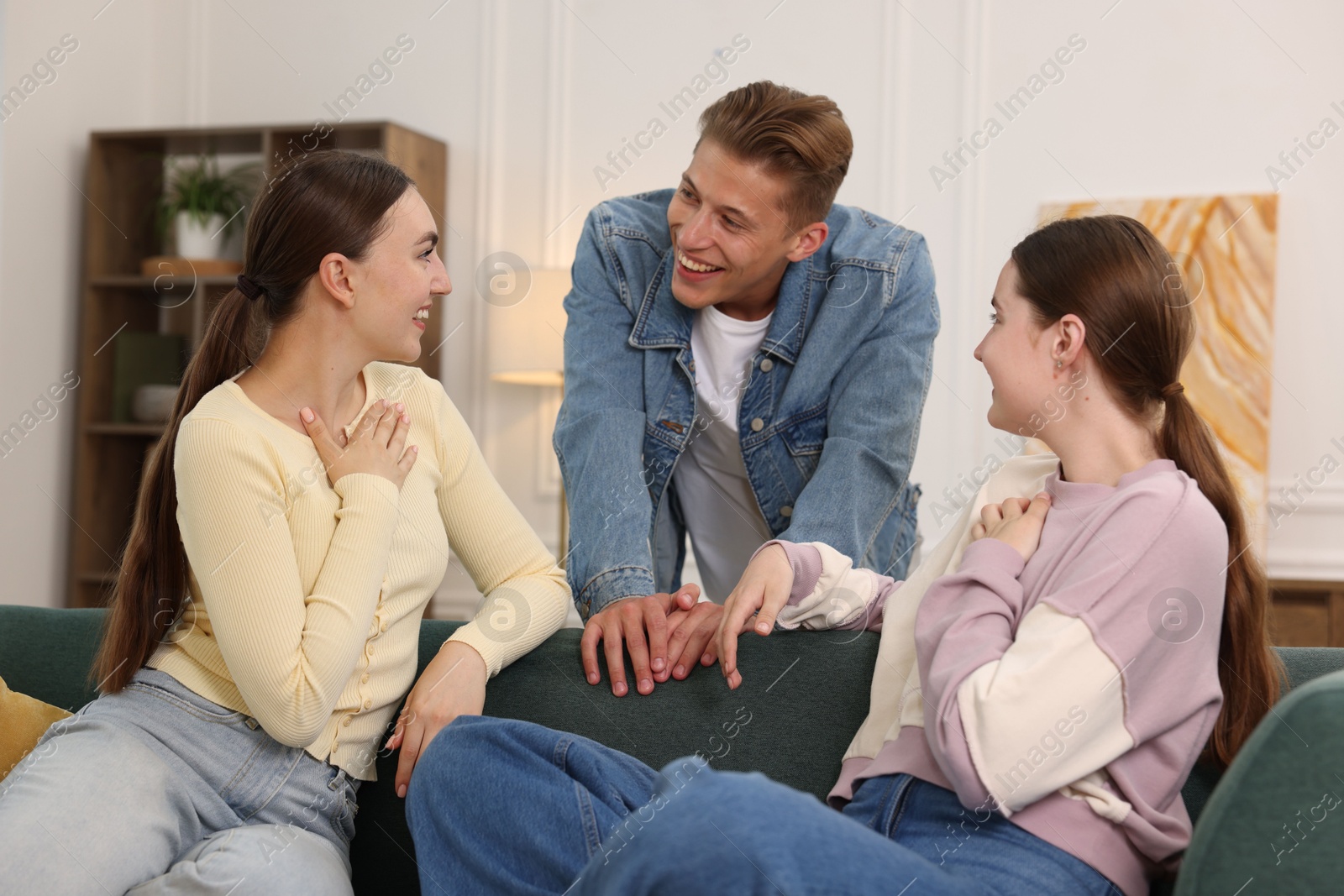Friends laughing on sofa indoors. Positive emotion Photo of Friends laughing on sofa indoors. Positive emotion