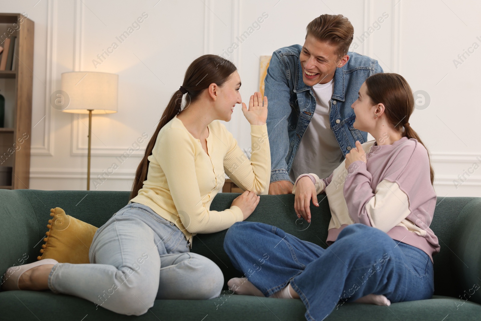Friends laughing on sofa indoors. Positive emotion Photo of Friends laughing on sofa indoors. Positive emotion