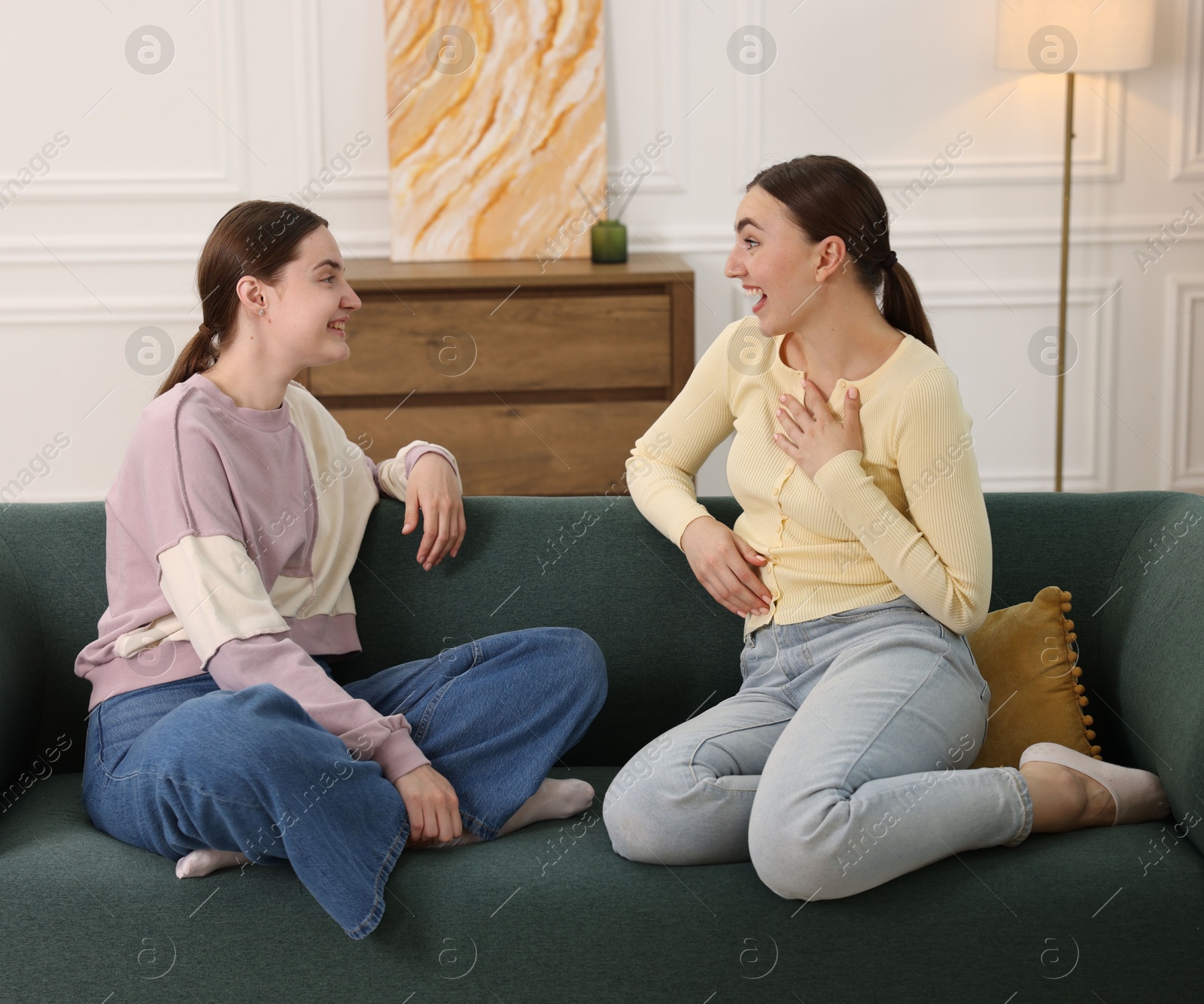 Friends laughing on sofa indoors. Positive emotion Photo of Friends laughing on sofa indoors. Positive emotion