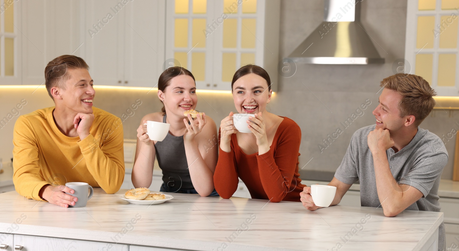 Friends with coffee laughing in kitchen. Positive emotion Photo of Friends with coffee laughing in kitchen. Positive emotion