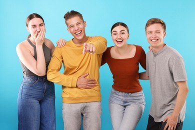 Photo of Friends laughing on light blue background. Positive emotion