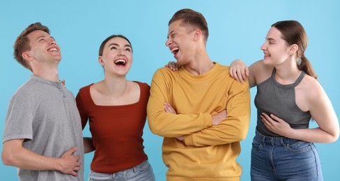 Photo of Friends laughing on light blue background. Positive emotion