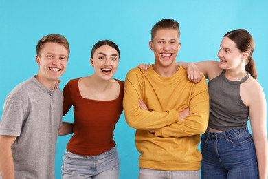 Photo of Friends laughing on light blue background. Positive emotion