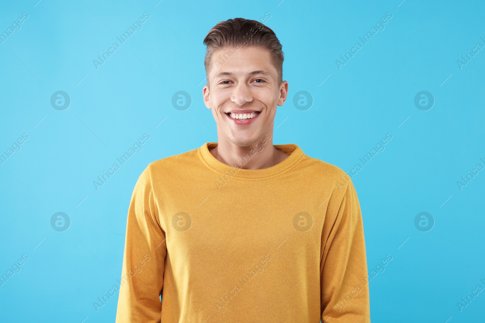 Handsome man laughing on light blue background. Positive emotion Photo of Handsome man laughing on light blue background. Positive emotion