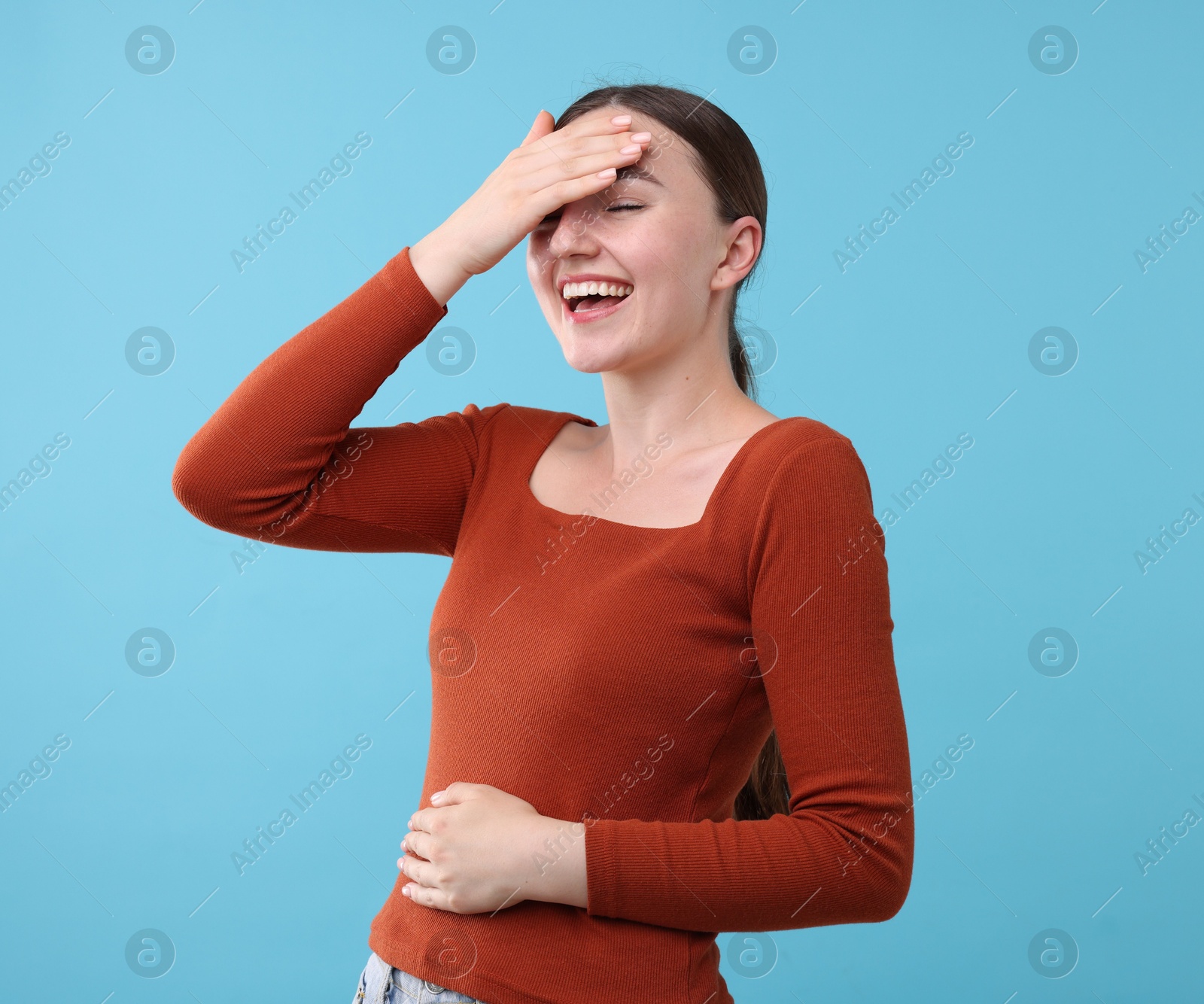 Beautiful woman laughing on light blue background. Positive emotion Photo of Beautiful woman laughing on light blue background. Positive emotion