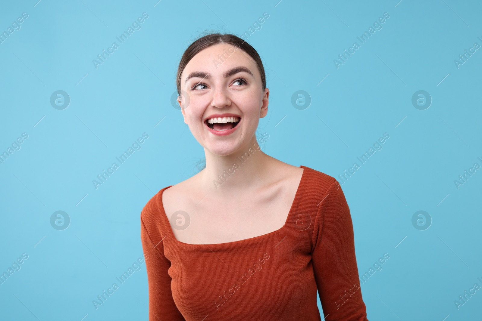 Beautiful woman laughing on light blue background. Positive emotion Photo of Beautiful woman laughing on light blue background. Positive emotion