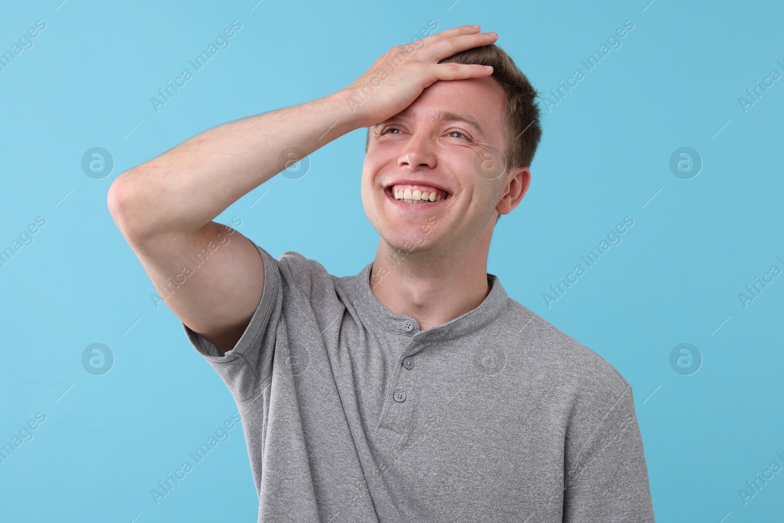 Handsome man laughing on light blue background. Positive emotion Photo of Handsome man laughing on light blue background. Positive emotion