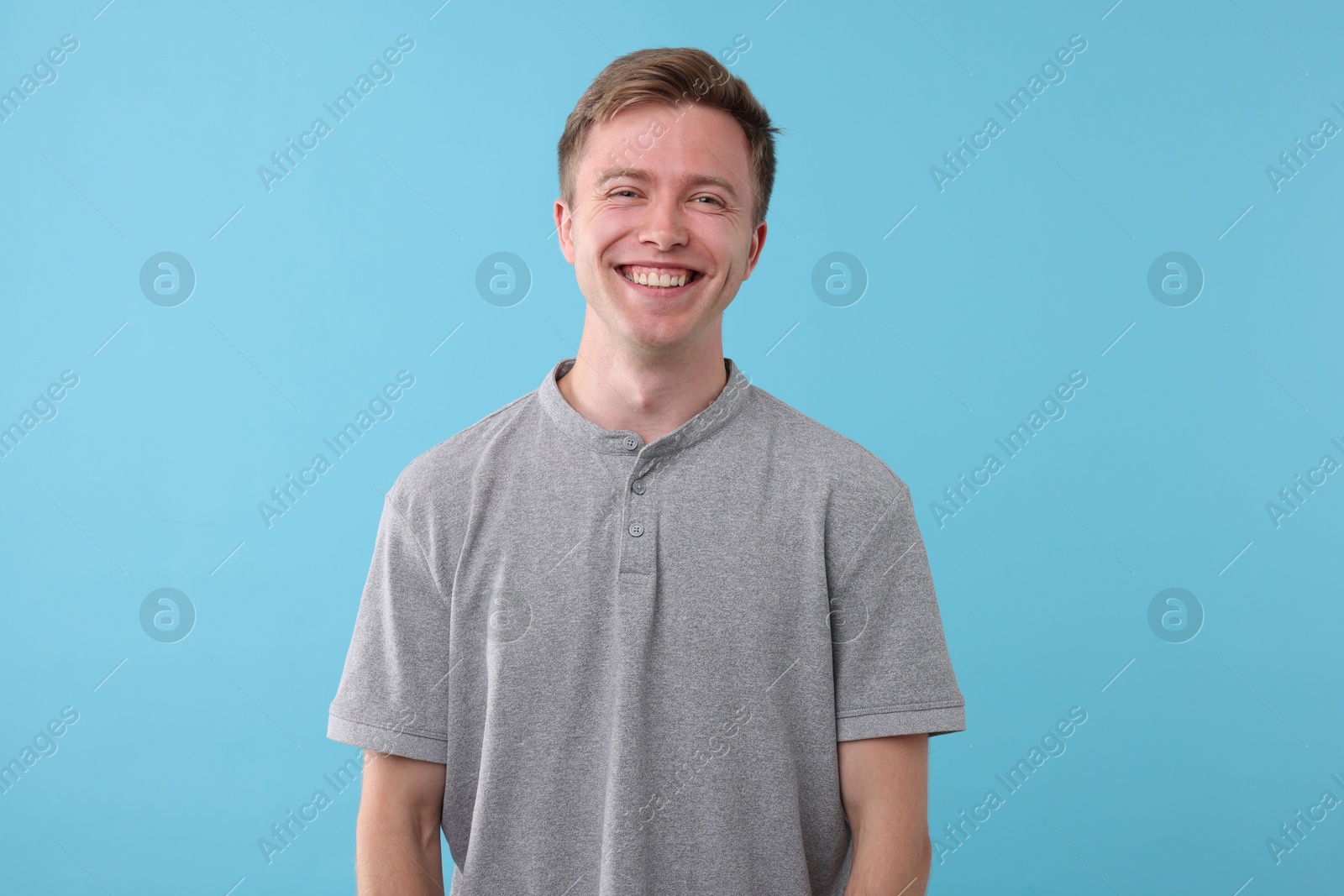 Handsome man laughing on light blue background. Positive emotion Photo of Handsome man laughing on light blue background. Positive emotion