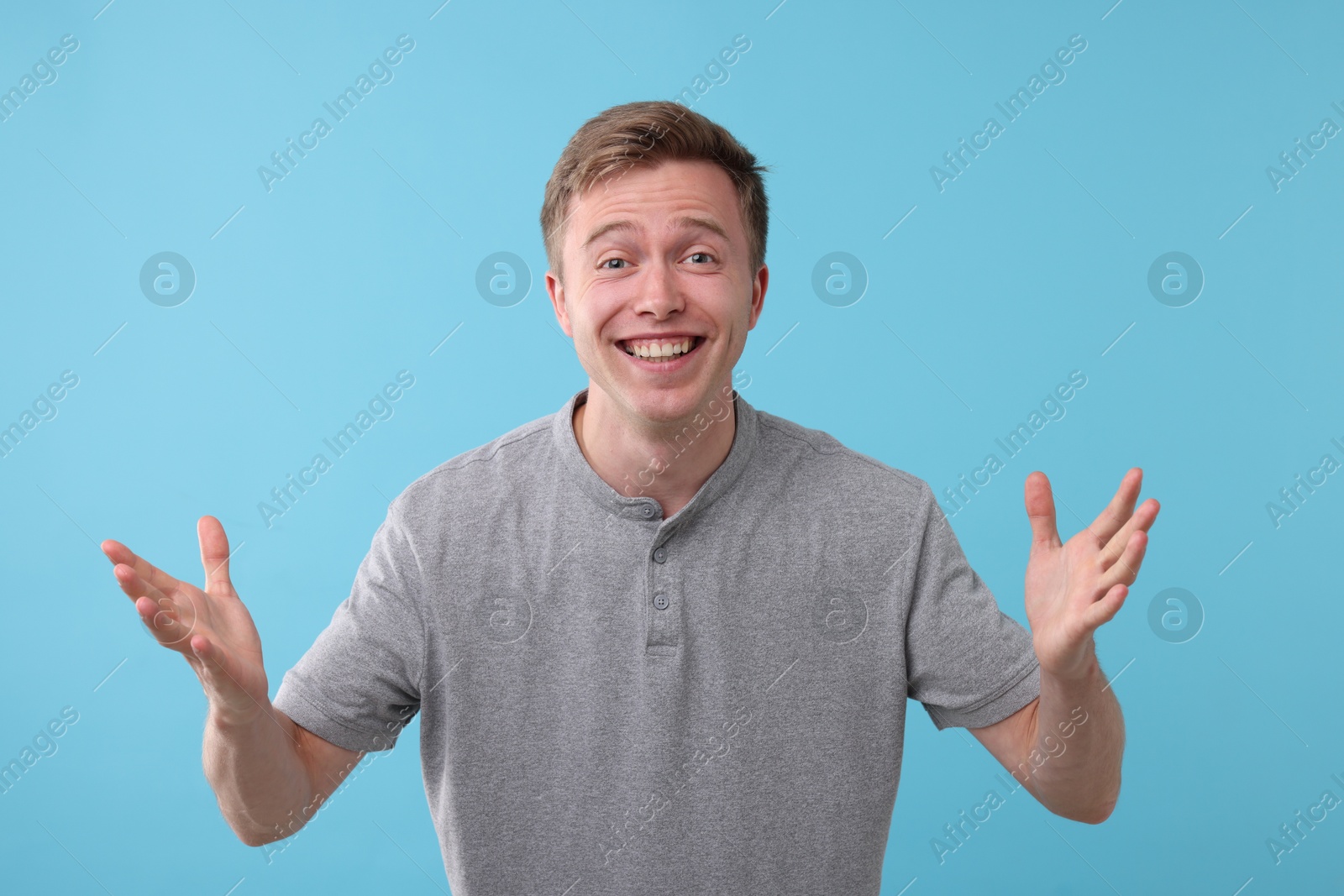 Handsome man laughing on light blue background. Positive emotion Photo of Handsome man laughing on light blue background. Positive emotion