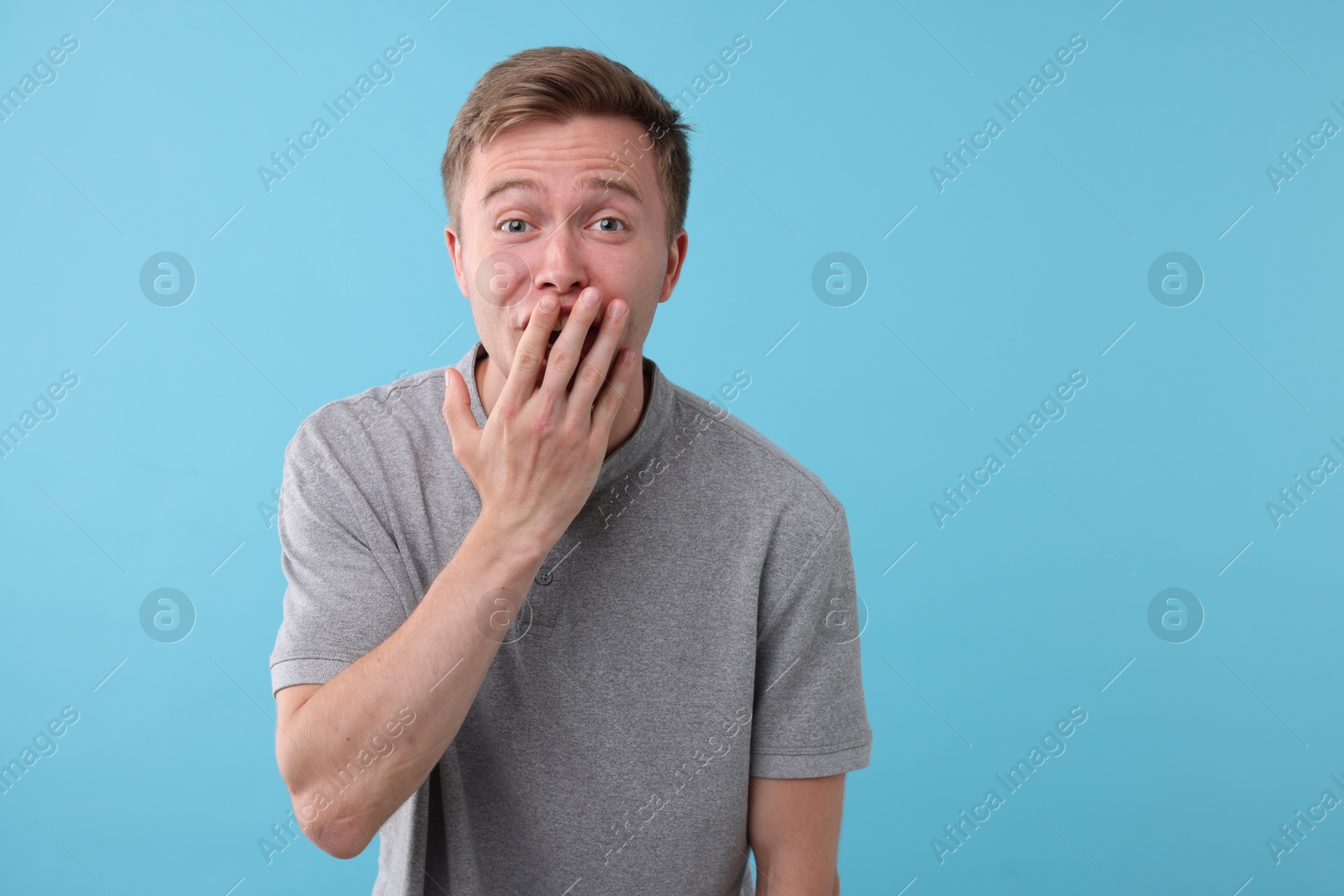 Handsome man laughing on light blue background. Positive emotion Photo of Handsome man laughing on light blue background. Positive emotion
