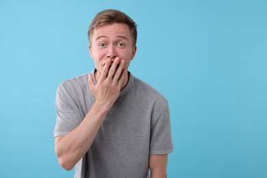 Photo of Handsome man laughing on light blue background. Positive emotion