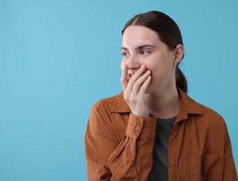 Photo of Beautiful woman laughing on light blue background. Space for text