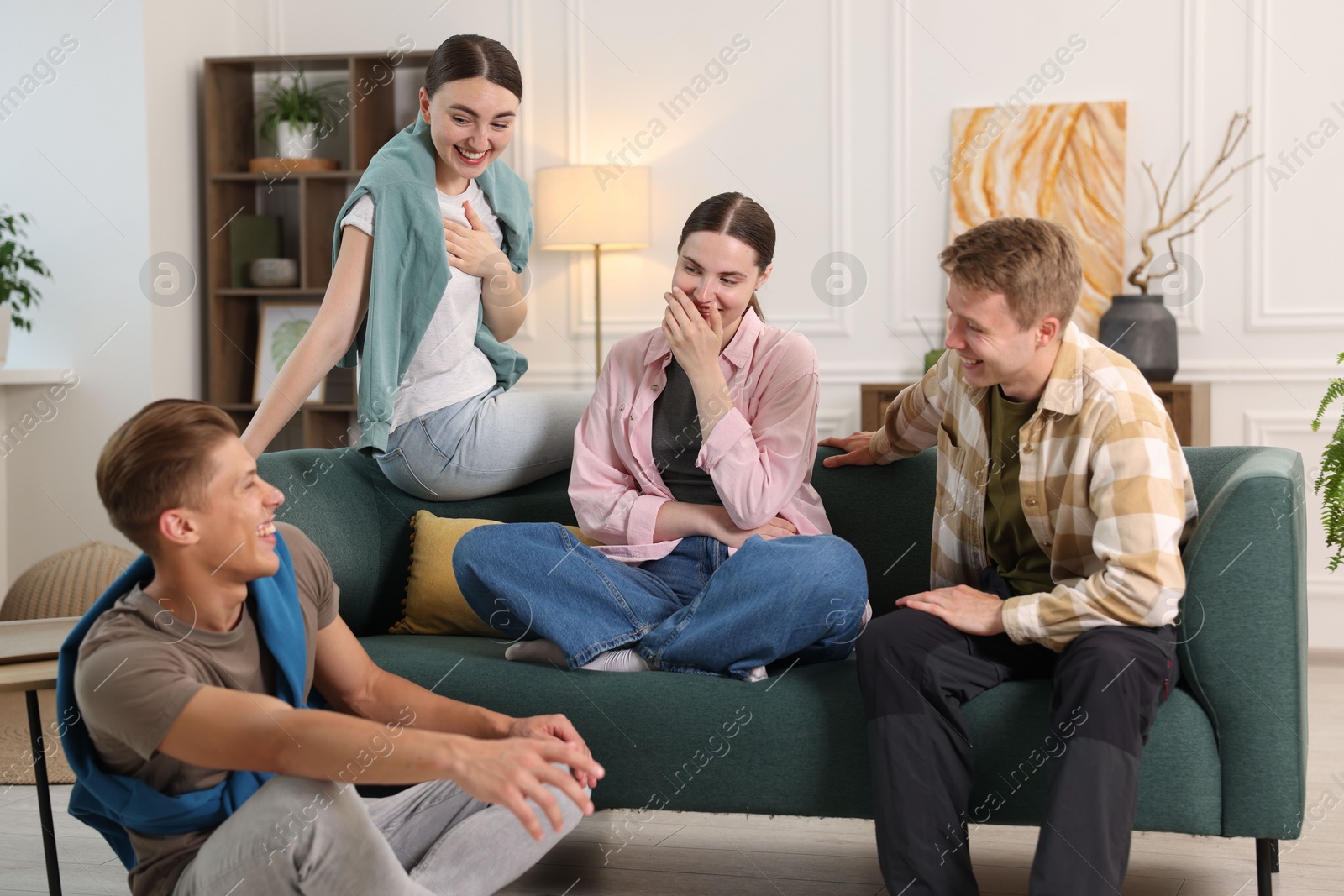 Friends laughing on sofa indoors. Positive emotion Photo of Friends laughing on sofa indoors. Positive emotion