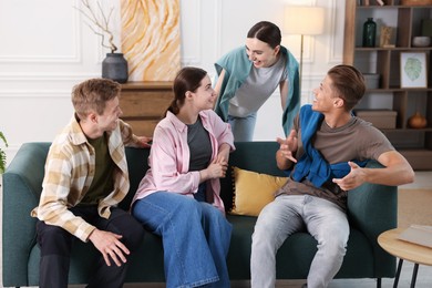 Photo of Friends laughing on sofa indoors. Positive emotion