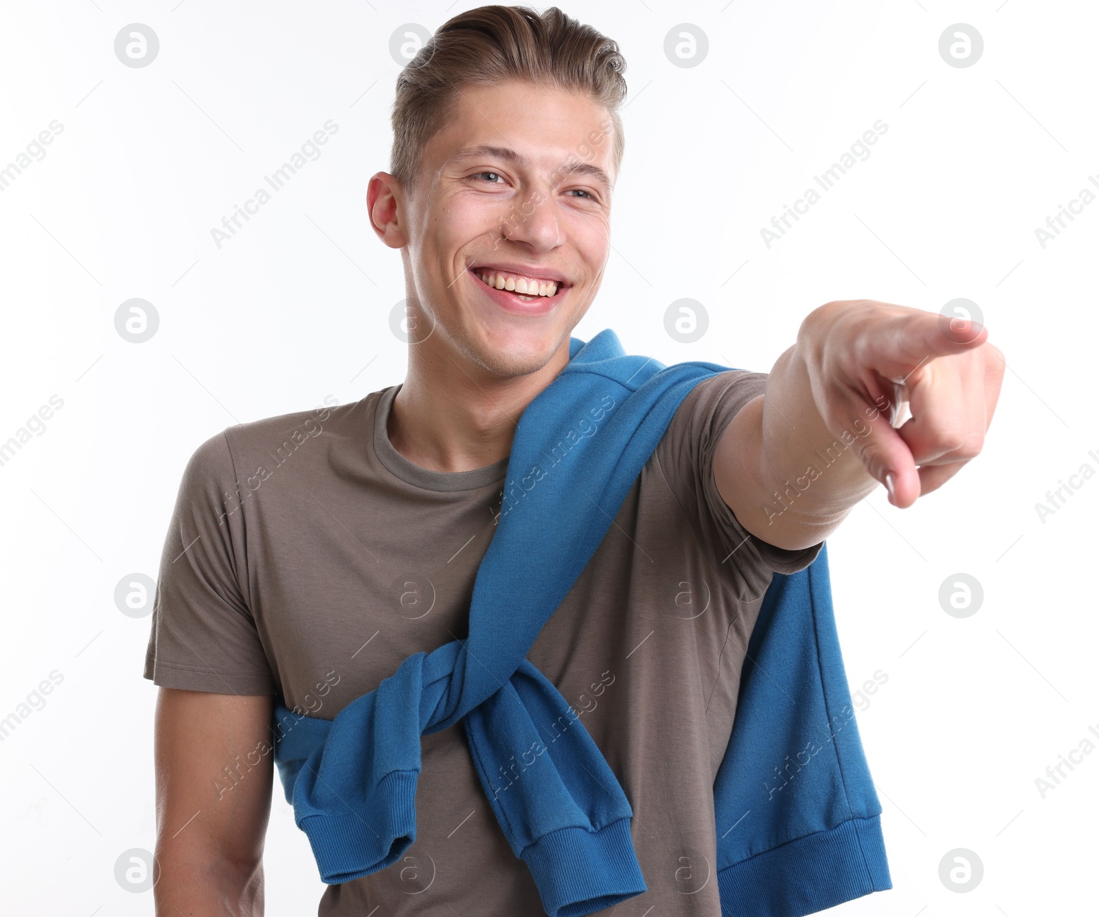 Handsome man laughing and pointing at something on white background. Positive emotion Photo of Handsome man laughing and pointing at something on white background. Positive emotion