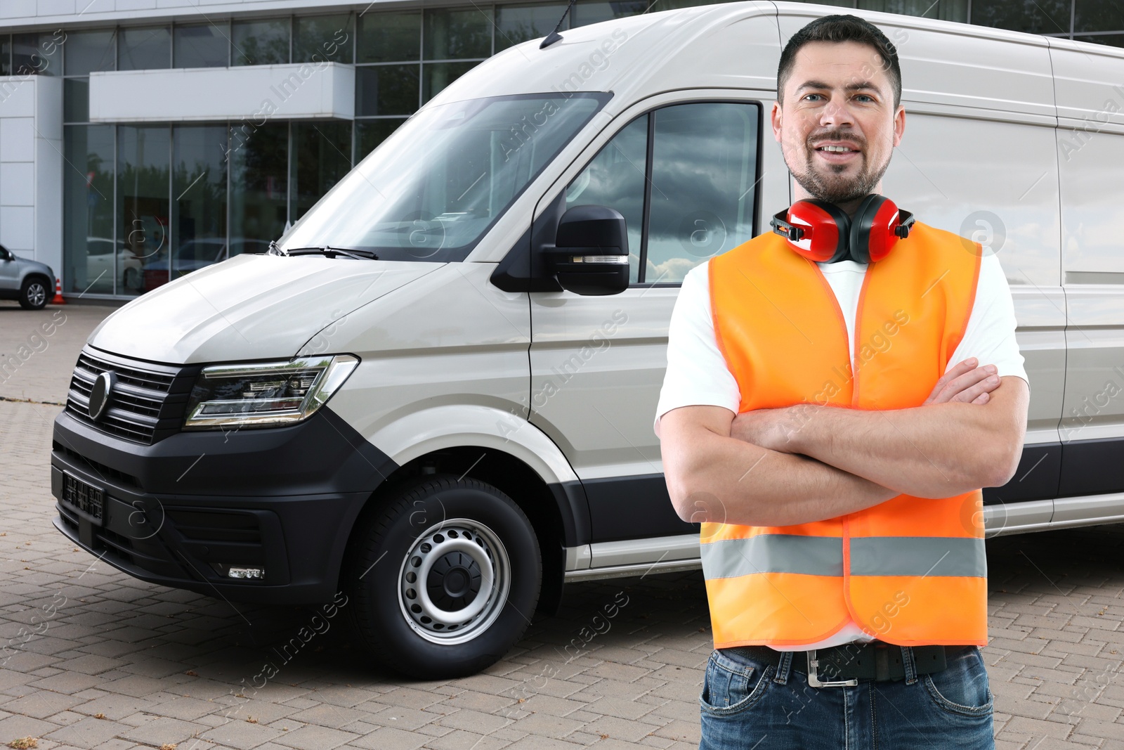 Image of Car service worker in orange vest and vehicle outdoors