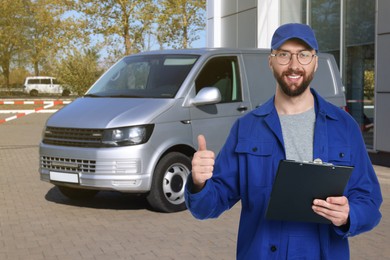 Image of Car service worker with clipboard showing thumbs-up against vehicle outdoors