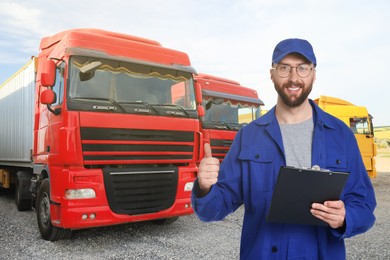 Image of Car service worker with clipboard showing thumbs-up against trucks outdoors