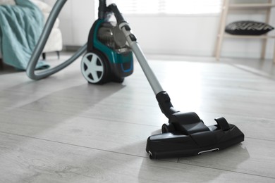 Photo of One vacuum cleaner on floor indoors. Household appliance