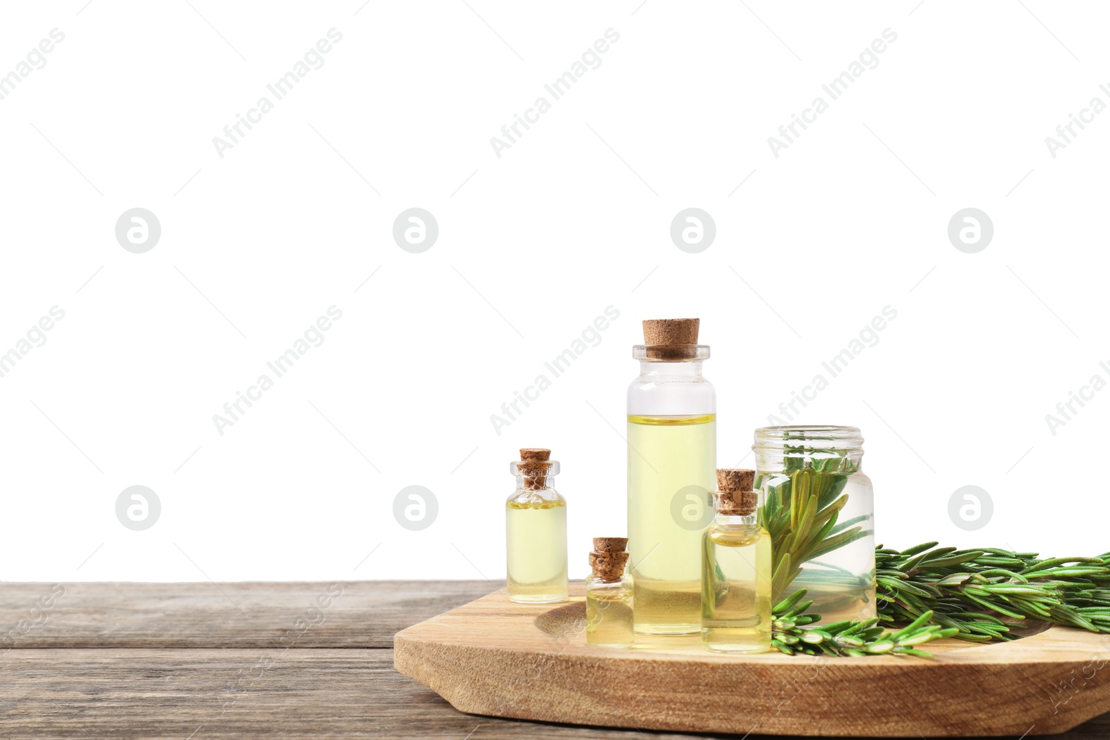 Photo of Bottles of essential oils and rosemary on wooden table against background