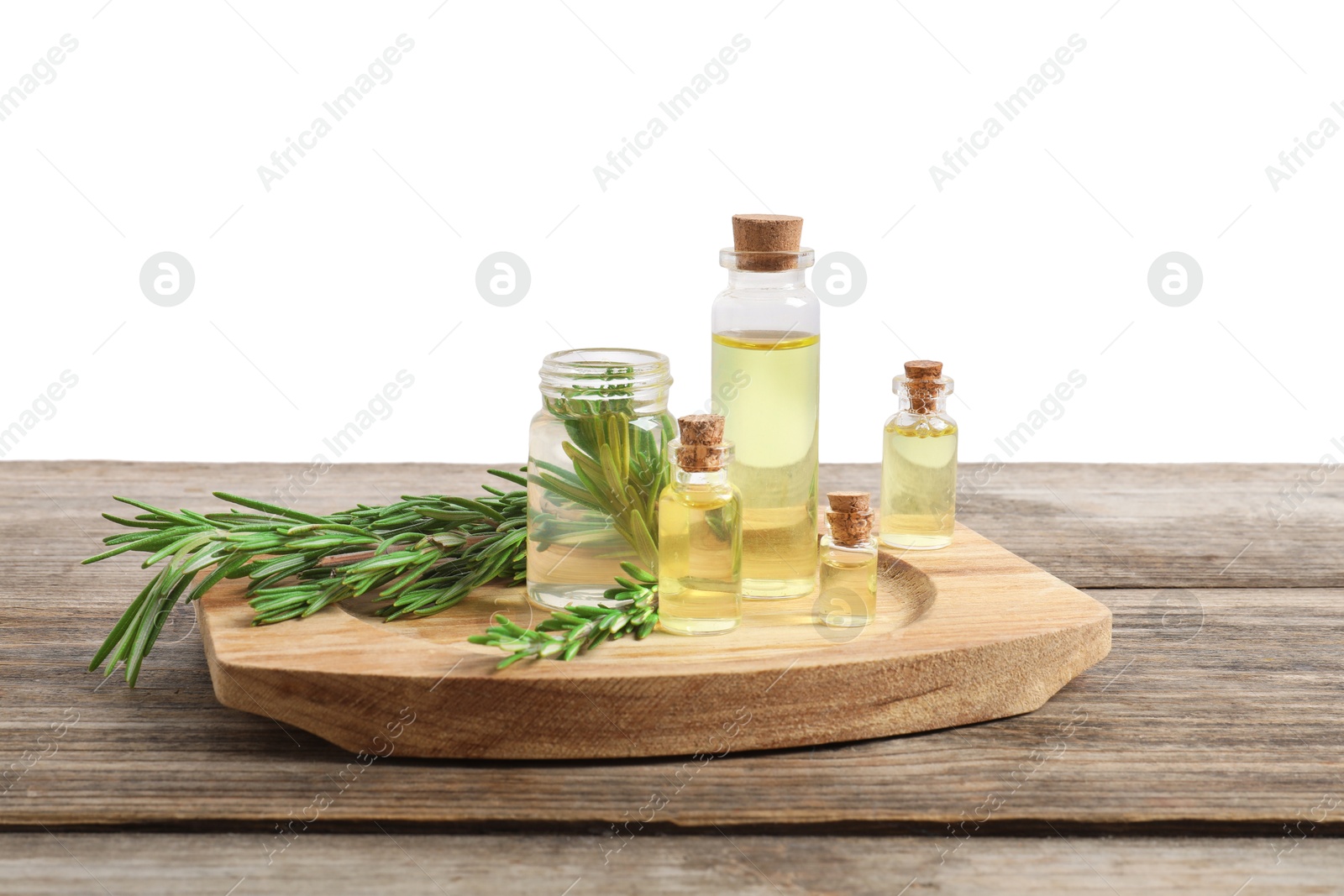 Photo of Bottles of essential oils and rosemary on wooden table against background