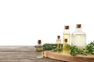 Photo of Bottles of essential oils, thyme and rosemary on wooden table against background