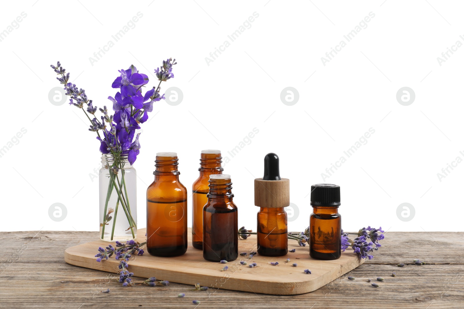 Photo of Bottles of essential oils and different plants on wooden table against white background