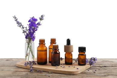 Photo of Bottles of essential oils and different plants on wooden table against white background