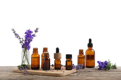 Photo of Bottles of essential oils and different plants on wooden table against white background