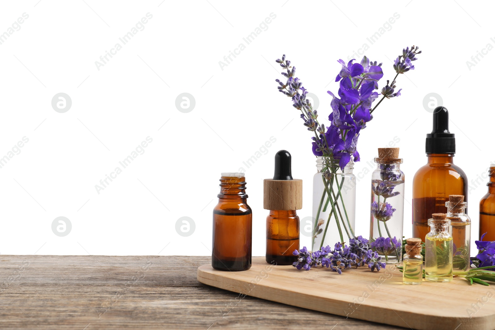 Photo of Bottles of essential oils and different plants on wooden table against white background