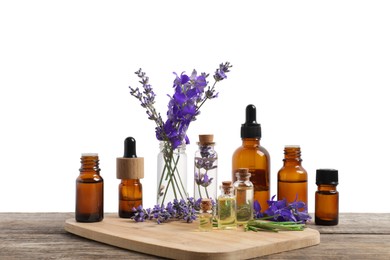 Photo of Bottles of essential oils and different plants on wooden table against white background