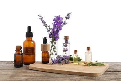 Photo of Bottles of essential oils and different plants on wooden table against white background