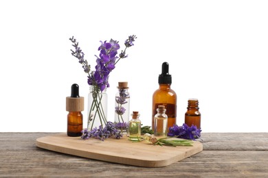 Photo of Bottles of essential oils and different plants on wooden table against white background